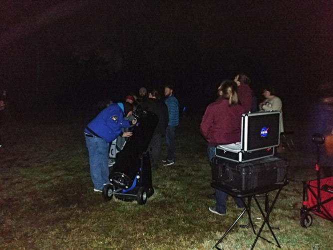 people looking through telescopes