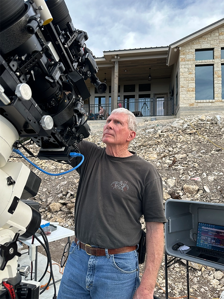 Lee Smith looking through eyepiece of his telescope and equipment